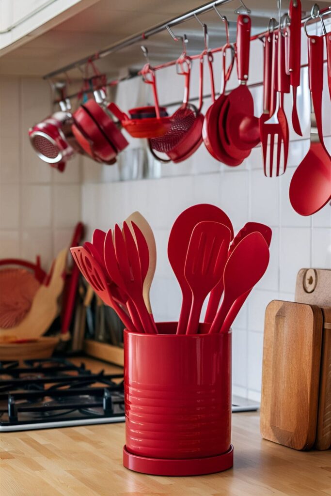 Kitchen countertop with red utensils in a red holder and various red kitchen gadgets hanging from a rack