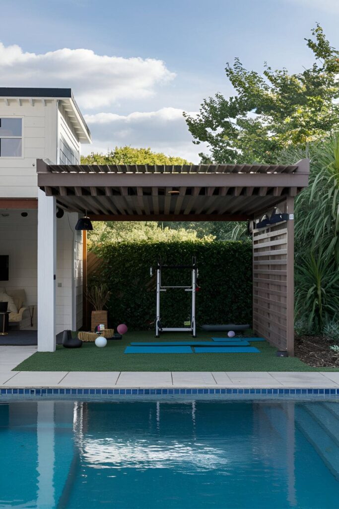 Outdoor exercise area next to a pool with yoga mats, pilates equipment, and weather-resistant gym gear