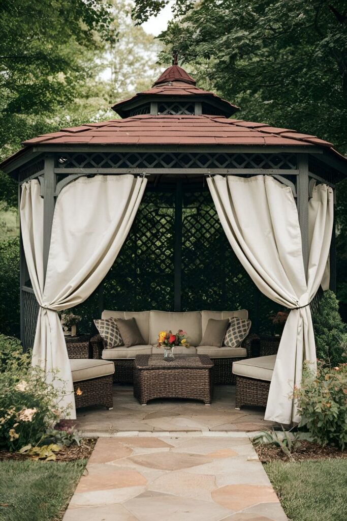 A cozy gazebo with flowing, weather-resistant curtains in a color that complements the patio furniture, providing privacy and shade