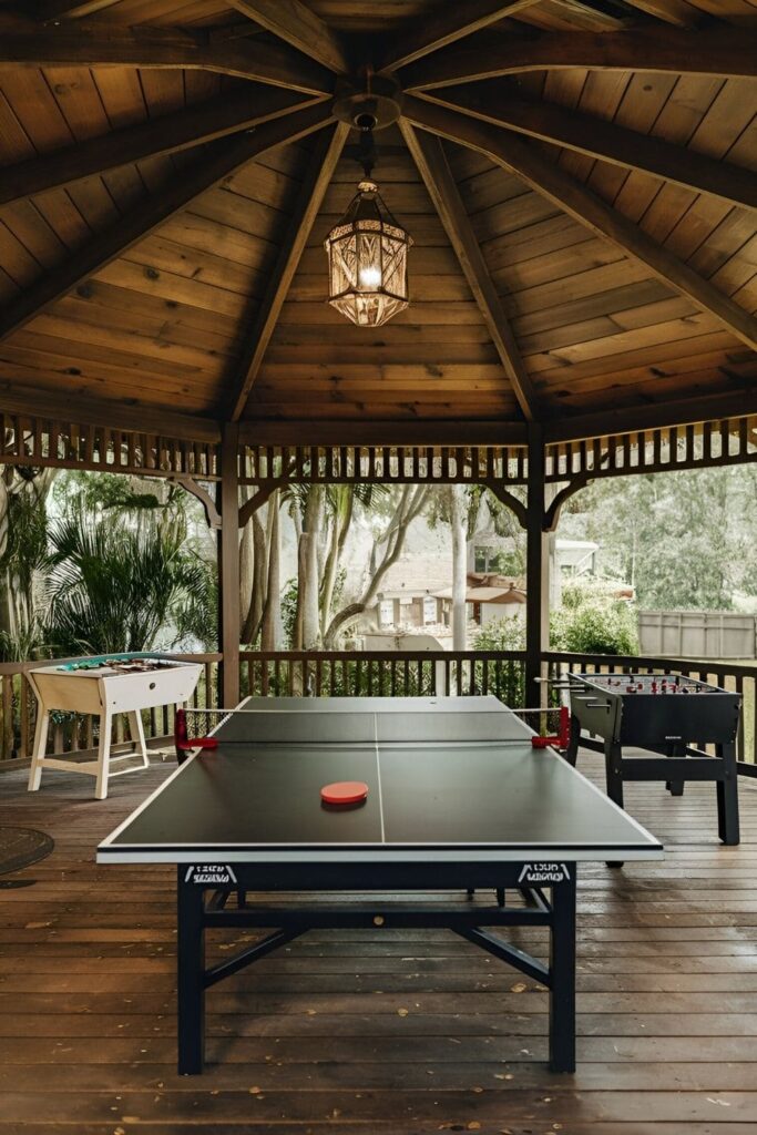 A fun, interactive gazebo with a game area, featuring a ping-pong table, foosball, and board games for entertaining guests of all ages