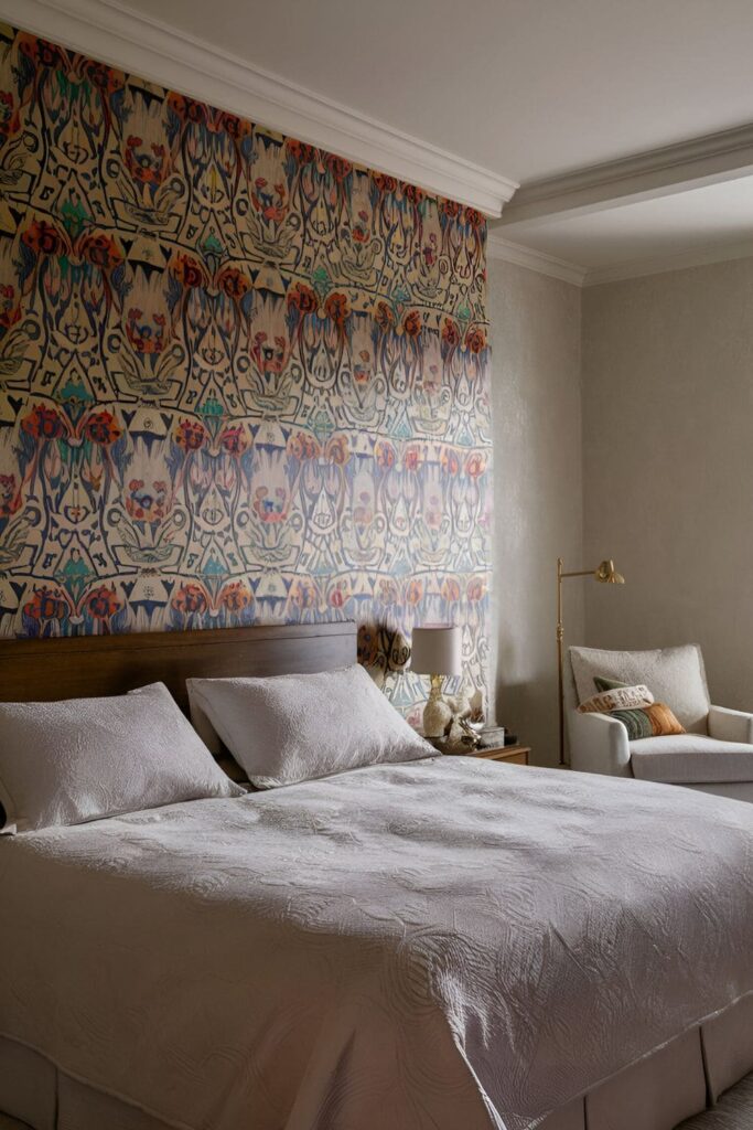 A master bedroom featuring bold patterned wallpaper on an accent wall, showcasing floral designs, geometric patterns, and textured wallpaper