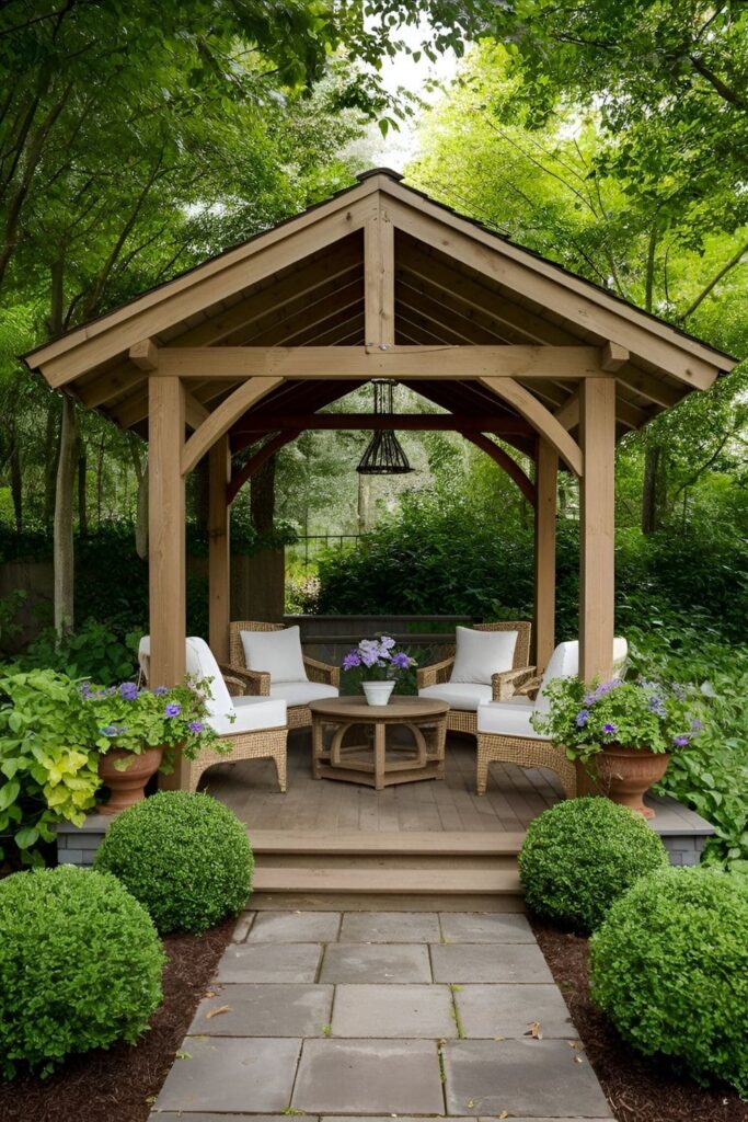 A traditional wooden gazebo, either in natural wood or painted to match a home’s exterior, paired with comfortable seating and potted plants for a welcoming atmosphere