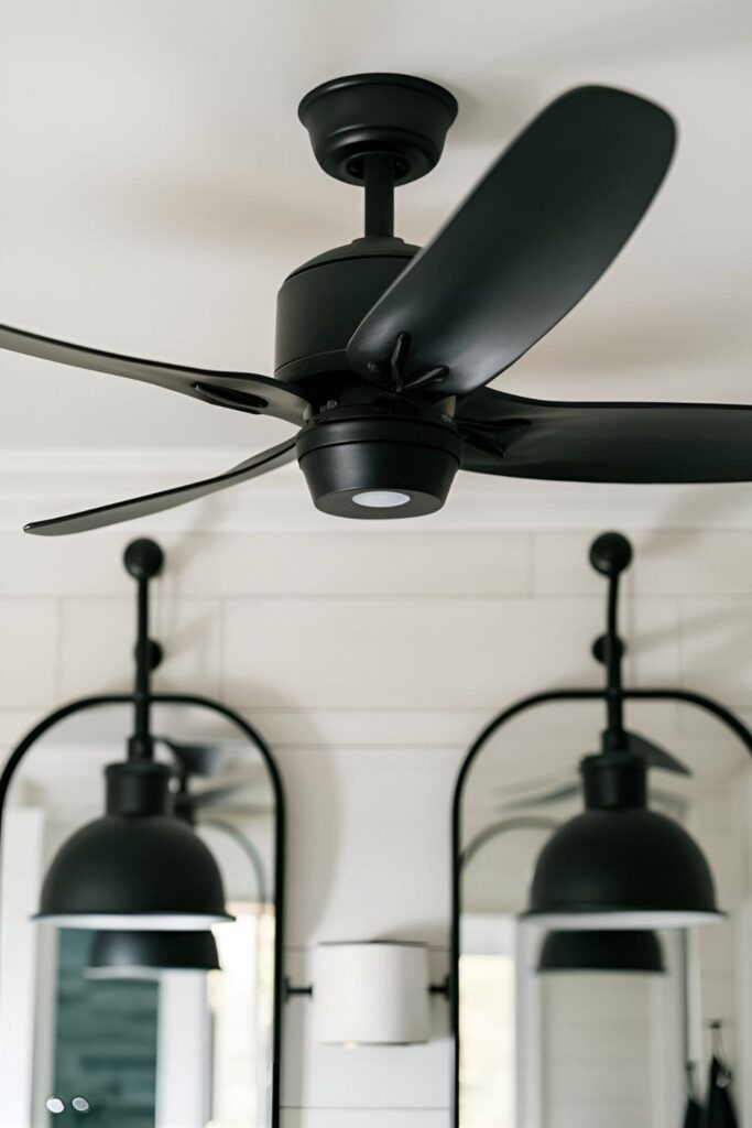 A bathroom with a sleek black ceiling fan and matching light fixtures, adding a modern touch to the contemporary decor