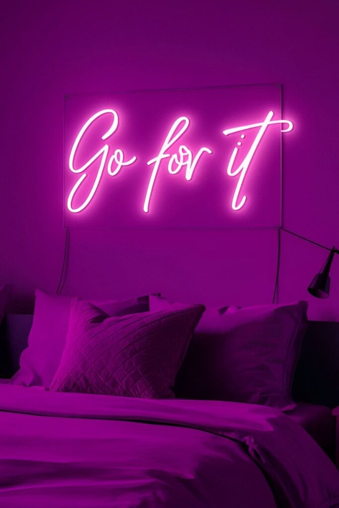 A trendy bedroom featuring a custom pink neon sign with an inspirational phrase for a modern vibe