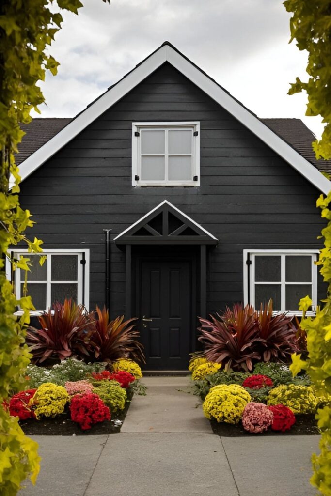 A black house surrounded by vibrant, colorful landscaping for bold contrast