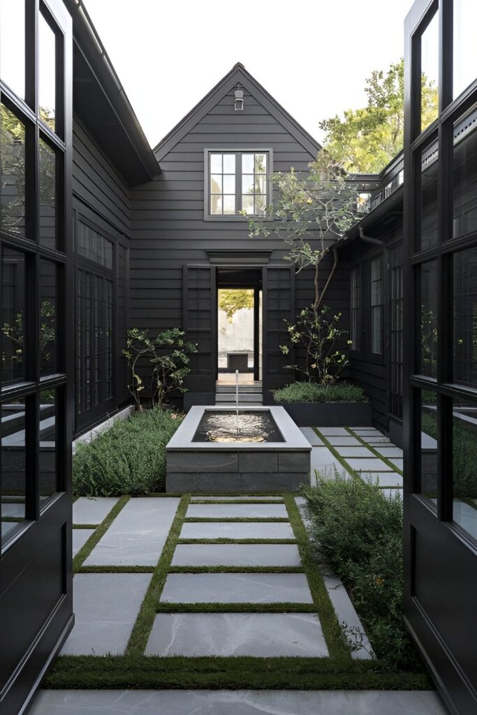 A black house surrounding an open-air courtyard with lush greenery