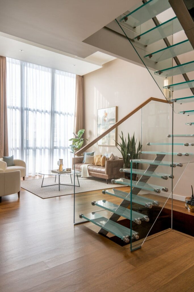 Elegant modern living room featuring glass staircases that allow light to flow through while maintaining a sophisticated look