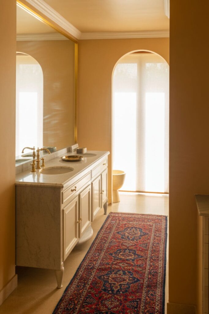 Persian-style designer rug placed in front of a floating vanity in an upscale bathroom