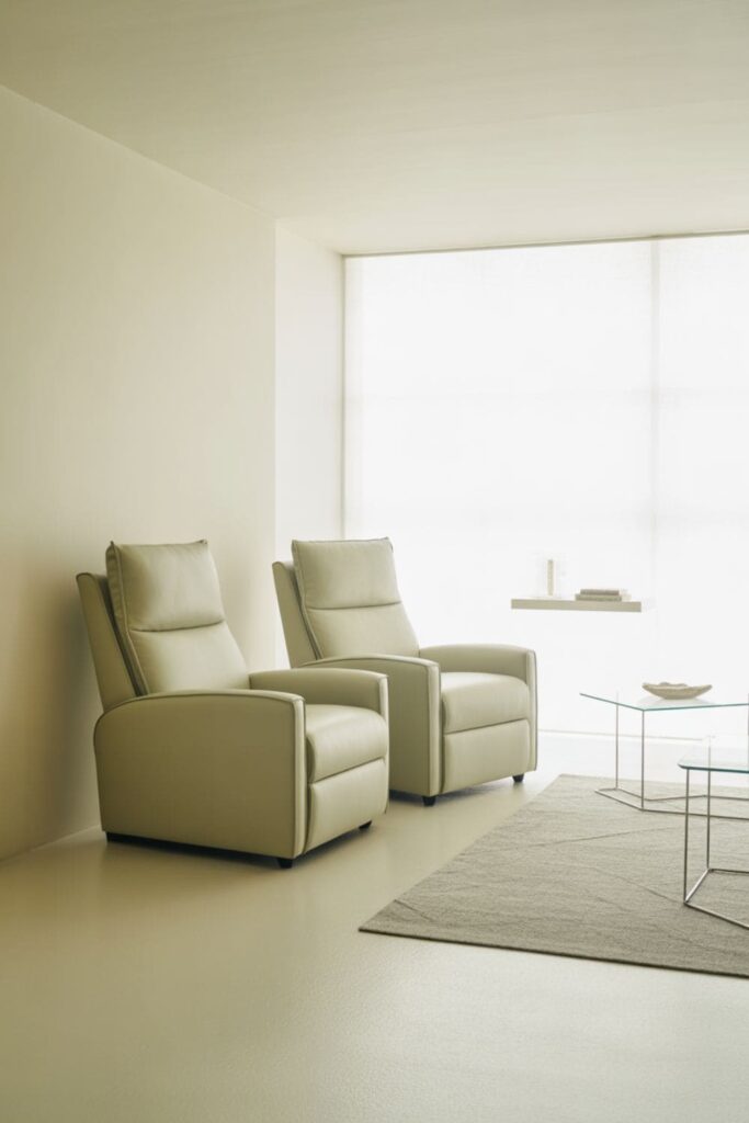 Compact living room with wall-hugger recliner, light-colored fabric, and uncluttered space