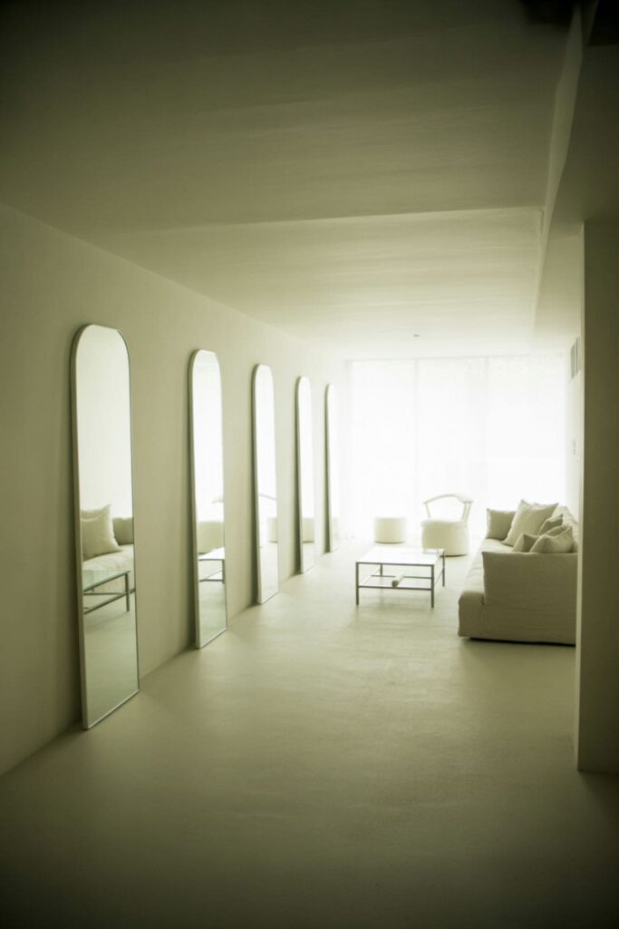 Cozy low-ceiling living room with recessed lighting, wall sconces, and modern neutral-colored furniture