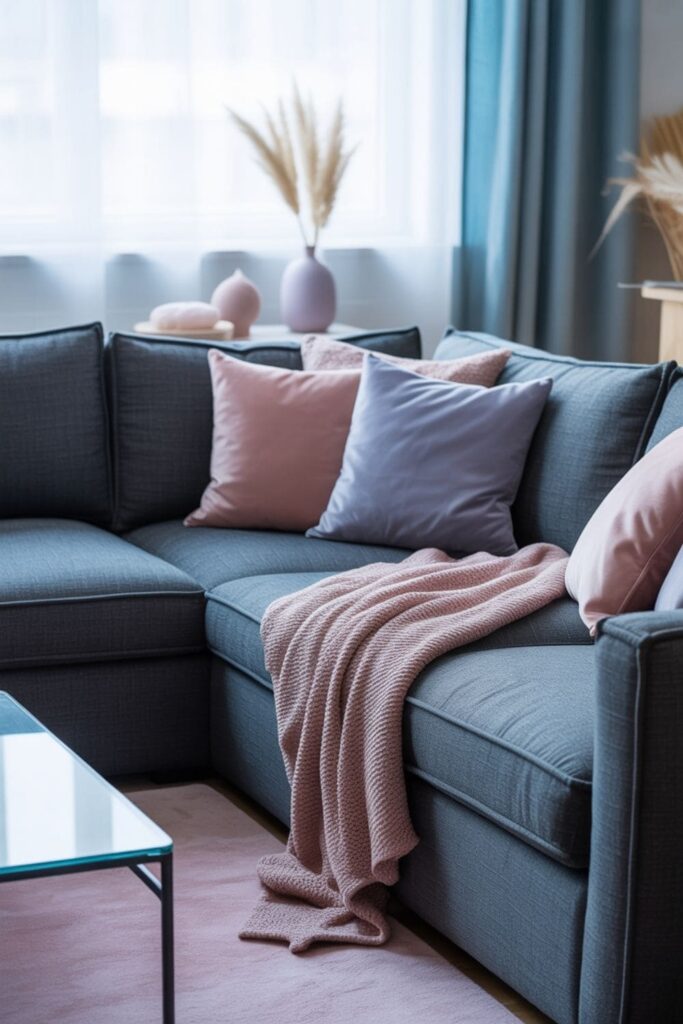 Grey couch styled with soft pastel colors in a calm living room