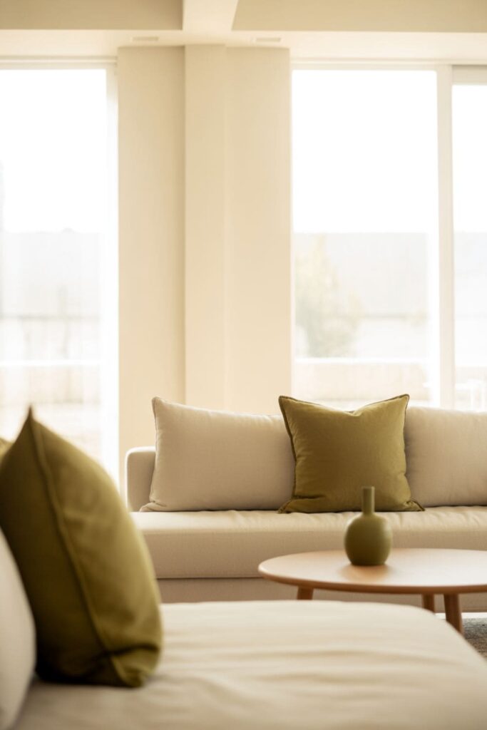 Minimalist living room with a neutral palette and one muted olive accent color