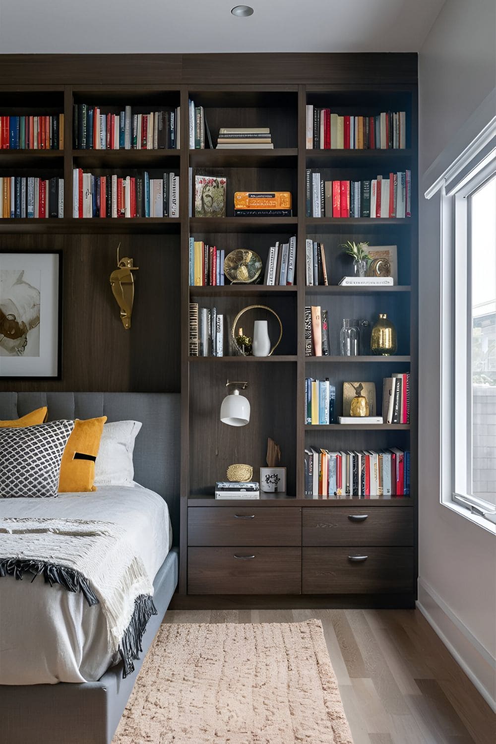 Built-in dark wood shelving filled with books decorative items and personal touches in a stylish bedroom