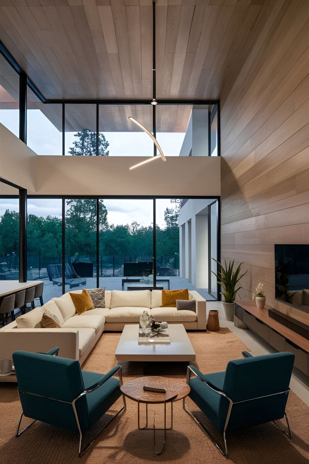 Open-concept living room with an I-shaped layout featuring a central sofa facing a modern media center a coffee table and accent chairs in a spacious room