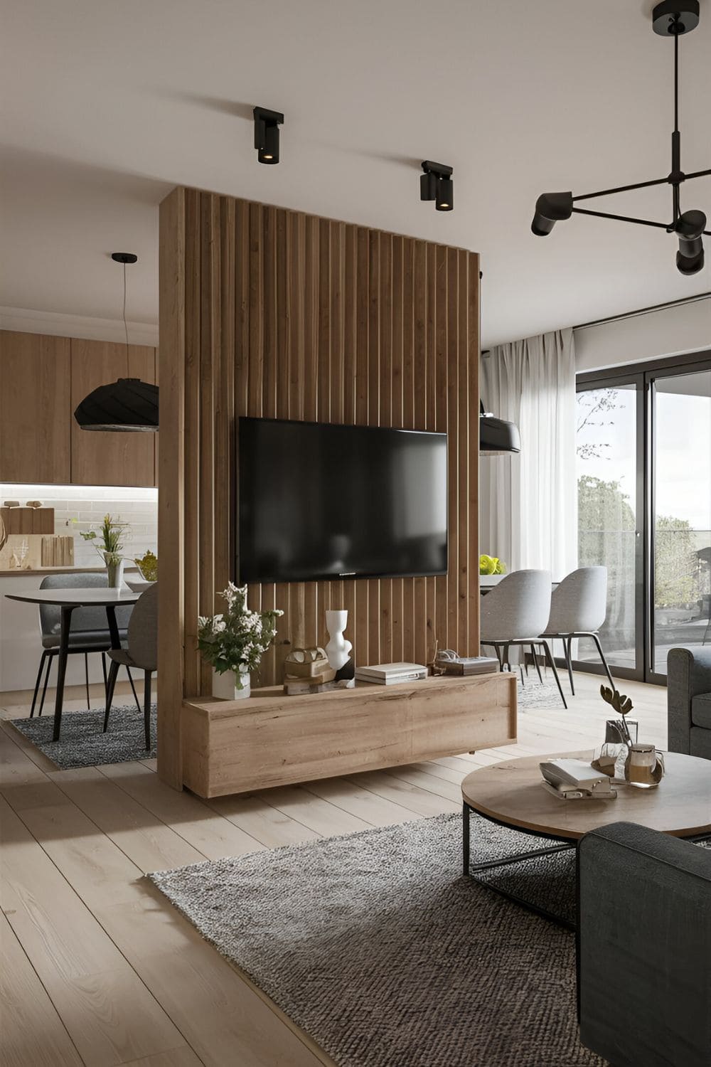 Open-plan living room with a partition wall housing a TV separating the space